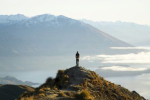 Une personne à proposer au sommet d'une montagne, surplombant un lac.